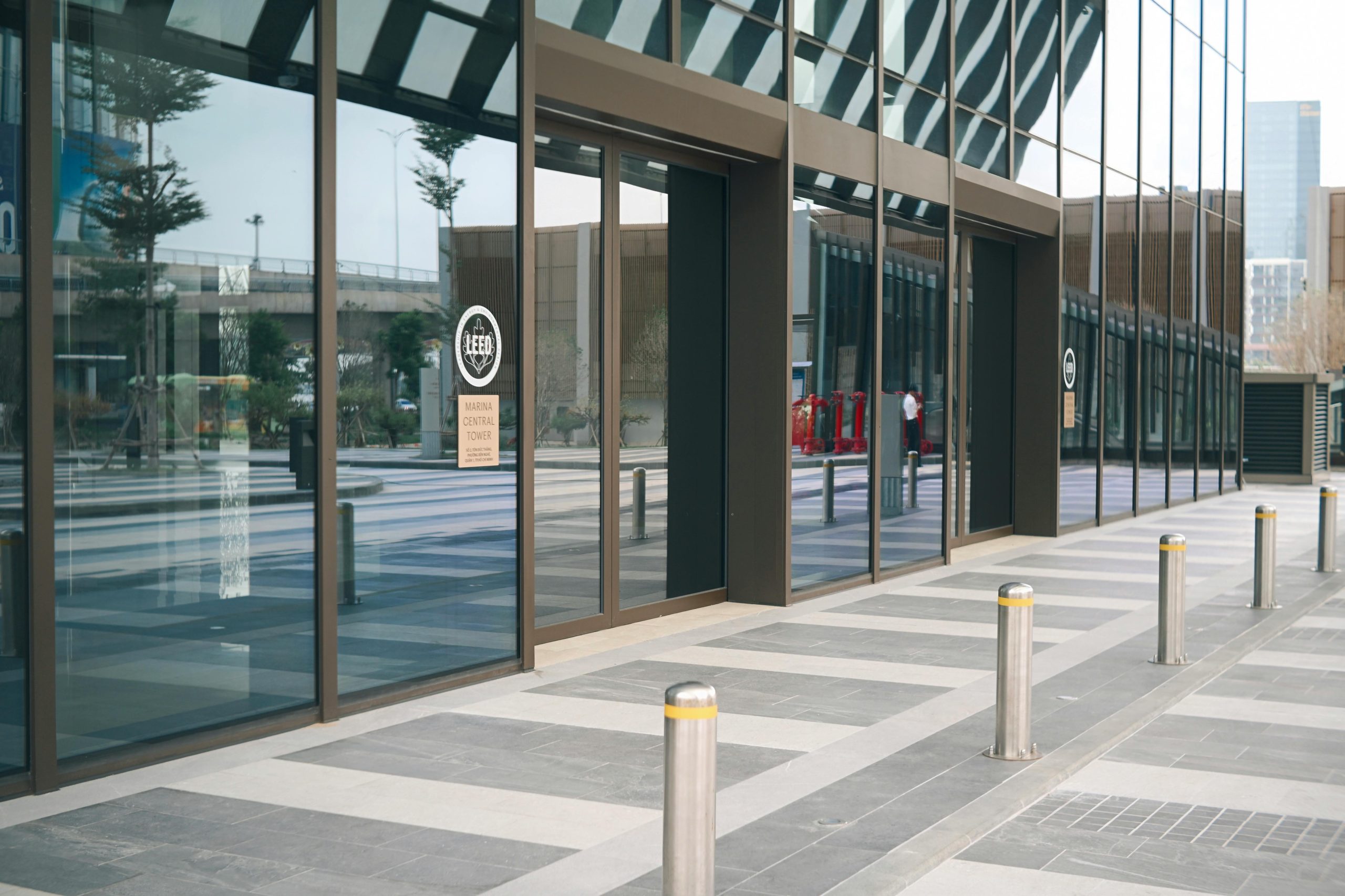 Sleek modern building exterior featuring glass windows and vertical pillars in a contemporary urban setting.